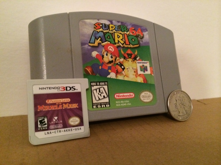Seen above is a Nintendo 3DS cartridge for “Professor Layton and the Miracle Mask,” the N64 cartridge for “Super Mario 64” and a quarter. 